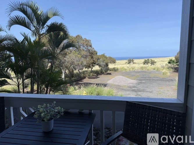 A balcony with a table and chairs overlooking a natural landscape.