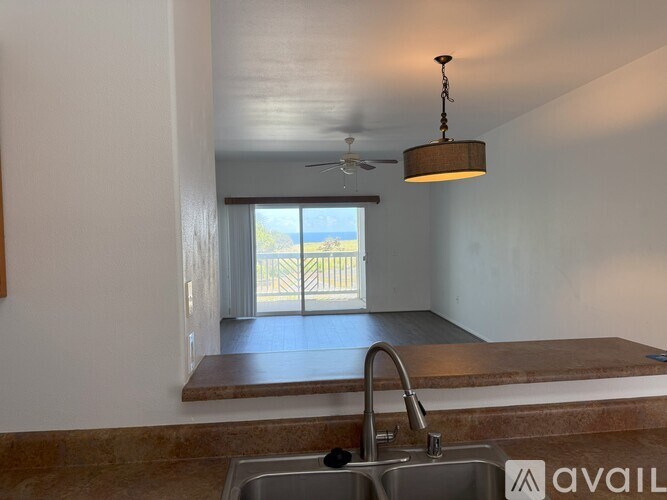 A kitchen with a sink and a ceiling fan.