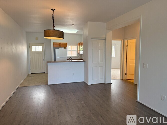 A room with a wooden floor and a hanging light fixture.