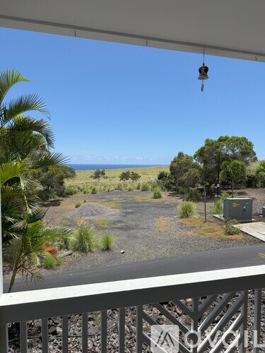 A view from a balcony overlooking a rocky landscape with a clear blue sky.