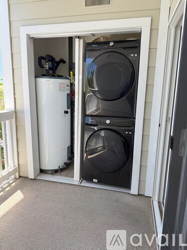 A washer and dryer are in a small outdoor cabinet.