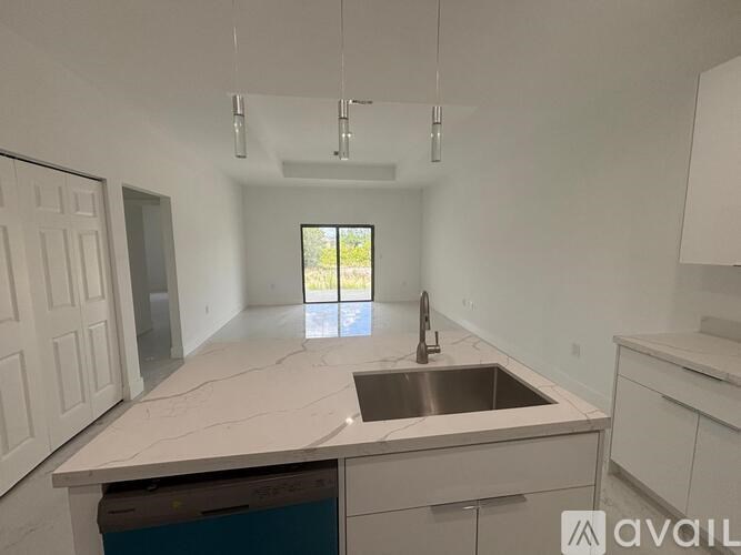 A kitchen with a marble countertop and a window letting in natural light.