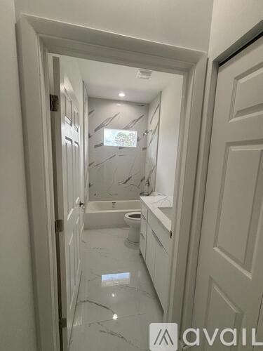 A bathroom with a toilet, sink and mirror.