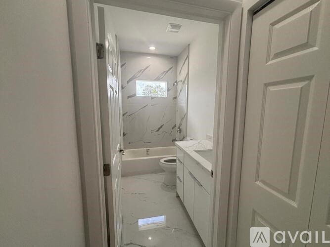 A bathroom with a toilet, sink, and mirror.