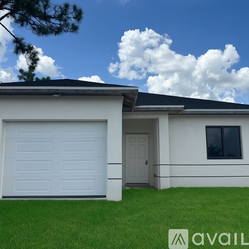 A white house with a black roof and a large white garage door.