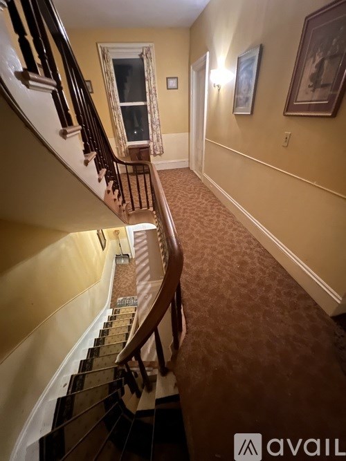 A staircase with a carpeted floor and wooden banister.