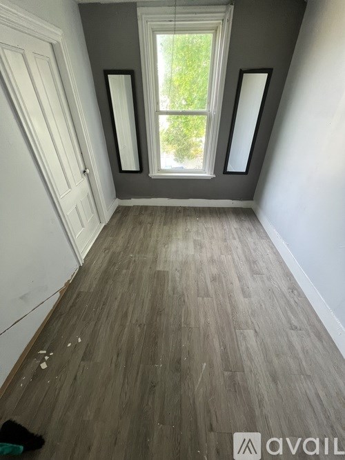 A room with a wooden floor and a window.