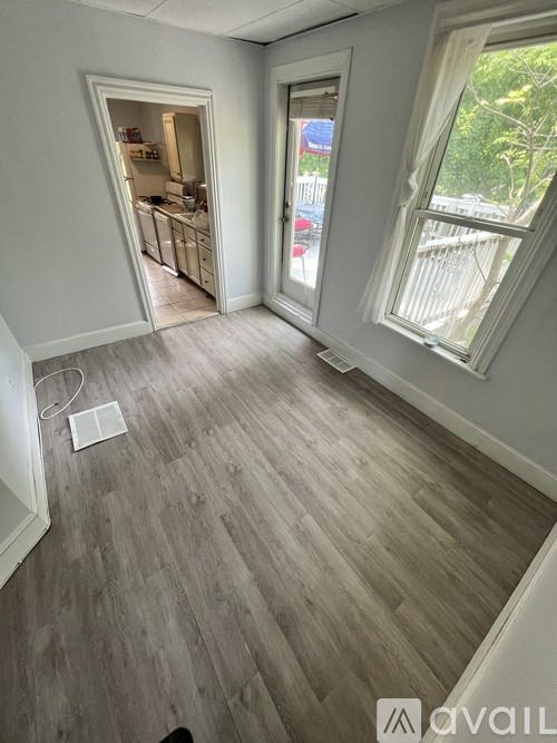 A room with a window and a door leading to a balcony.