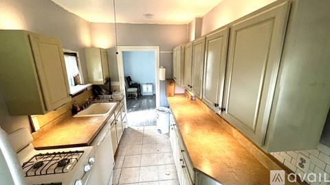A kitchen with white cabinets and a tiled floor.