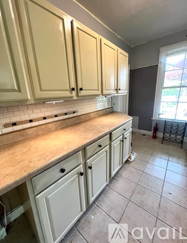 A kitchen with beige cabinets and a tiled floor.