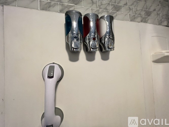 A wall-mounted hand dryer is below a pair of foot pedals.