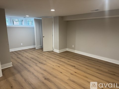 A room with wooden flooring and a window.