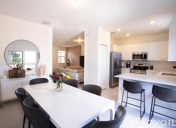 A modern kitchen with a dining table and chairs.