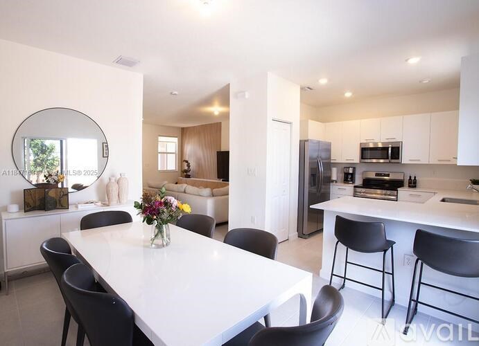 A modern kitchen with a dining table and chairs.