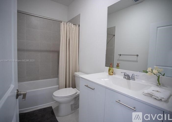 A white bathroom with a toilet, sink, and shower.