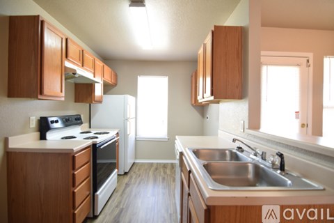 A kitchen with wooden cabinets and a stove top oven.