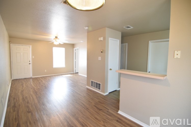 A spacious room with wooden floors and a large window.