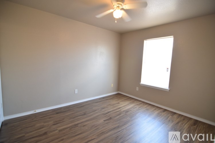 A room with wooden flooring and a ceiling fan.