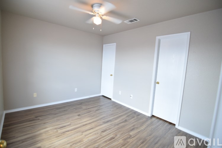 A room with a ceiling fan and two doors.