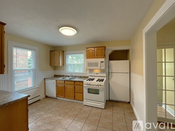 A kitchen with white appliances and wooden cabinets.