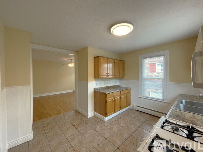 A kitchen with a stove, sink, and cabinets.