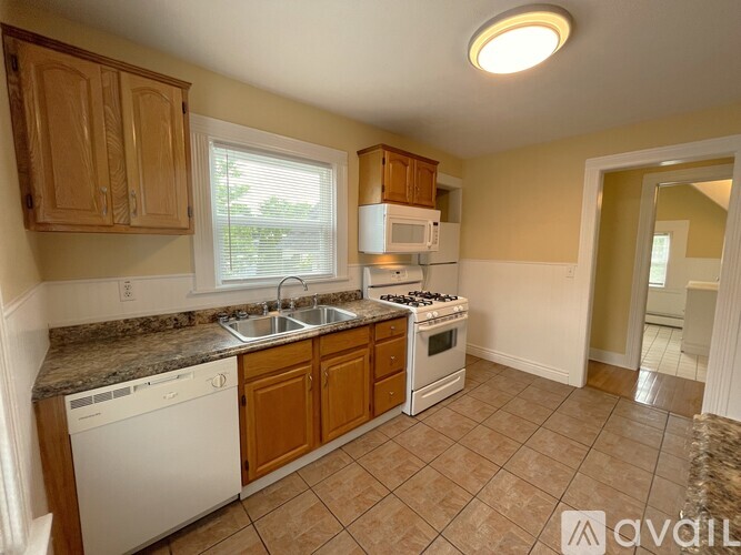 A kitchen with a white dishwasher and a white microwave.