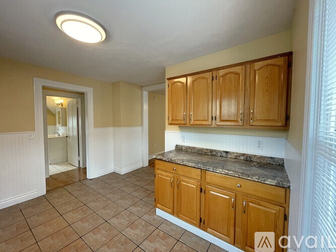 A kitchen with wooden cabinets and a marble countertop.