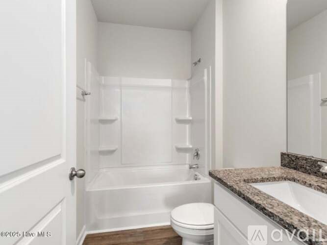 A white bathroom with a toilet, sink, and bathtub.