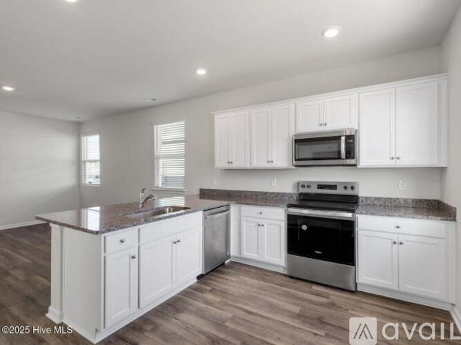 A kitchen with white cabinets and a granite countertop.