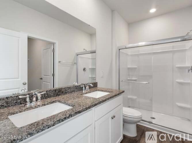 A bathroom with a granite countertop and white fixtures.