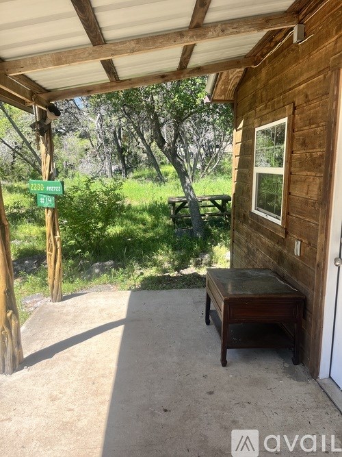 A wooden building with a bench in front and a green sign with the number 2215 on it.