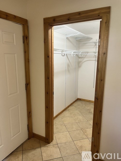 A room with a white door and a mirror on the wall.