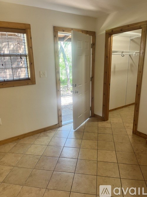 A room with a tiled floor and a door leading outside.