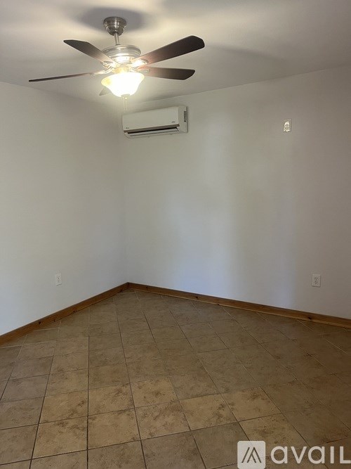 A room with a ceiling fan and tiled floor.