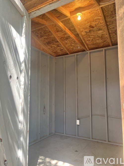 A room under construction with wooden beams on the ceiling.