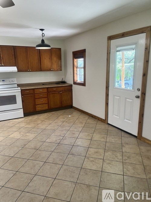 A kitchen with white appliances and wooden cabinets.