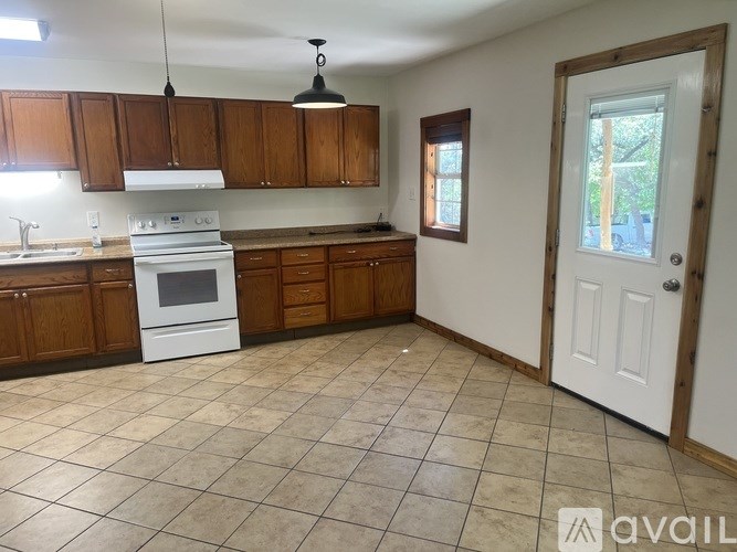 A kitchen with wooden cabinets and a white stove top oven.