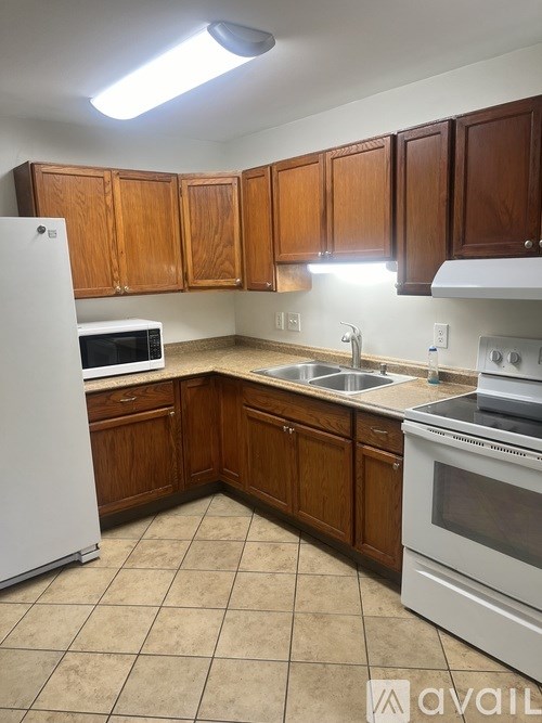 A kitchen with wooden cabinets and white appliances.