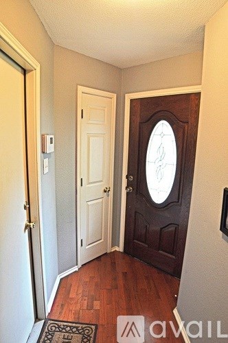 A hallway with a brown door and a white door.