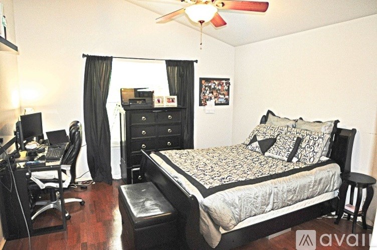 A bedroom with a bed, desk, and chair.