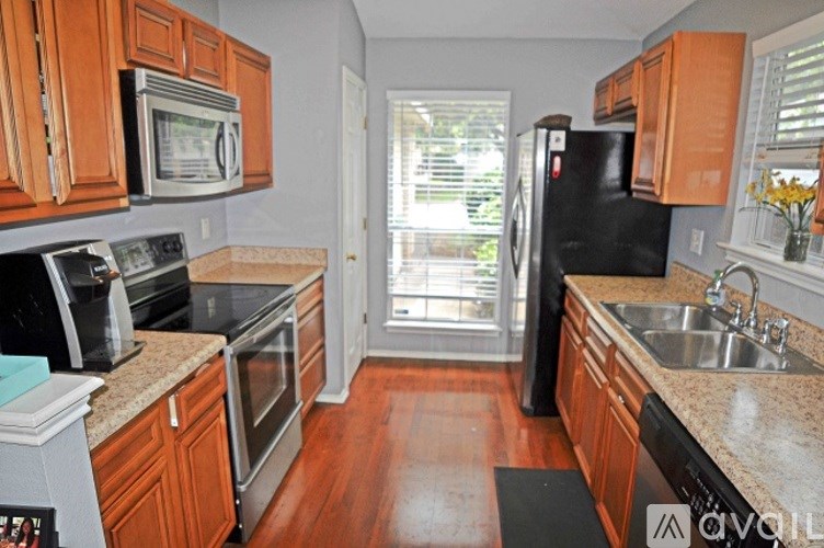 A kitchen with wooden cabinets and a black refrigerator.