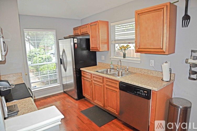 A kitchen with wooden cabinets and a black refrigerator.