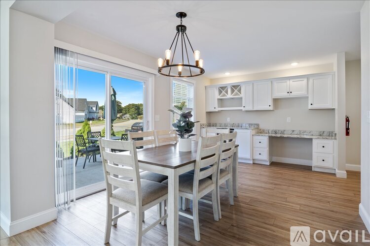 A dining room with a table set for four and a view of the backyard.