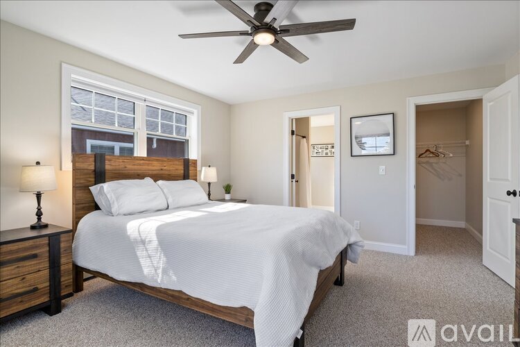 A bedroom with a bed, dresser, and window.