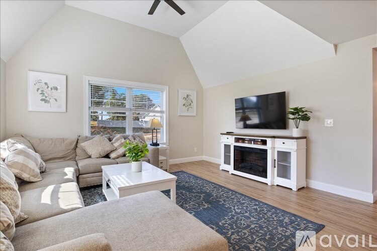 A living room with a couch, a coffee table, and a television.