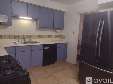 A kitchen with purple cabinets and a black stove top.