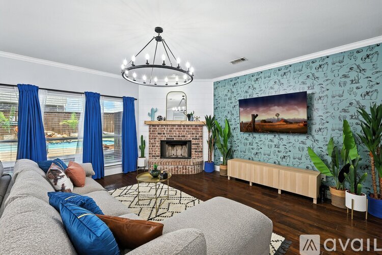 A living room with a grey couch and a fireplace.