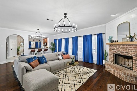 A living room with a grey couch and a fireplace.