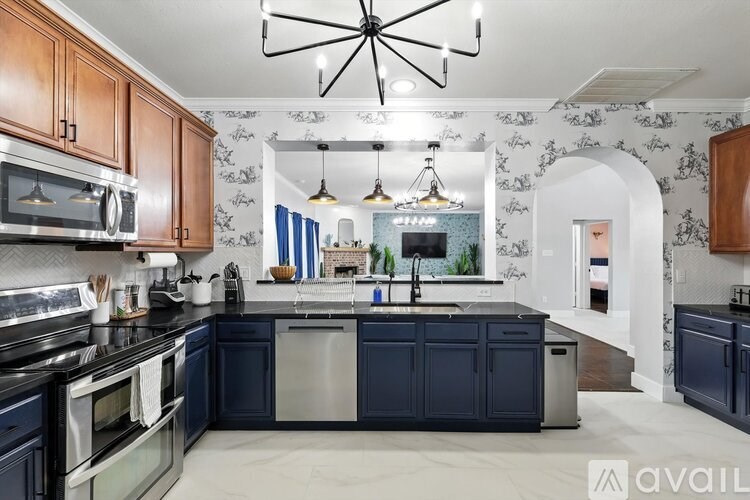 A modern kitchen with dark blue cabinets and a central island.