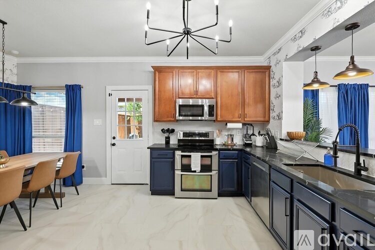 A modern kitchen with wooden cabinets and a blue accent wall.